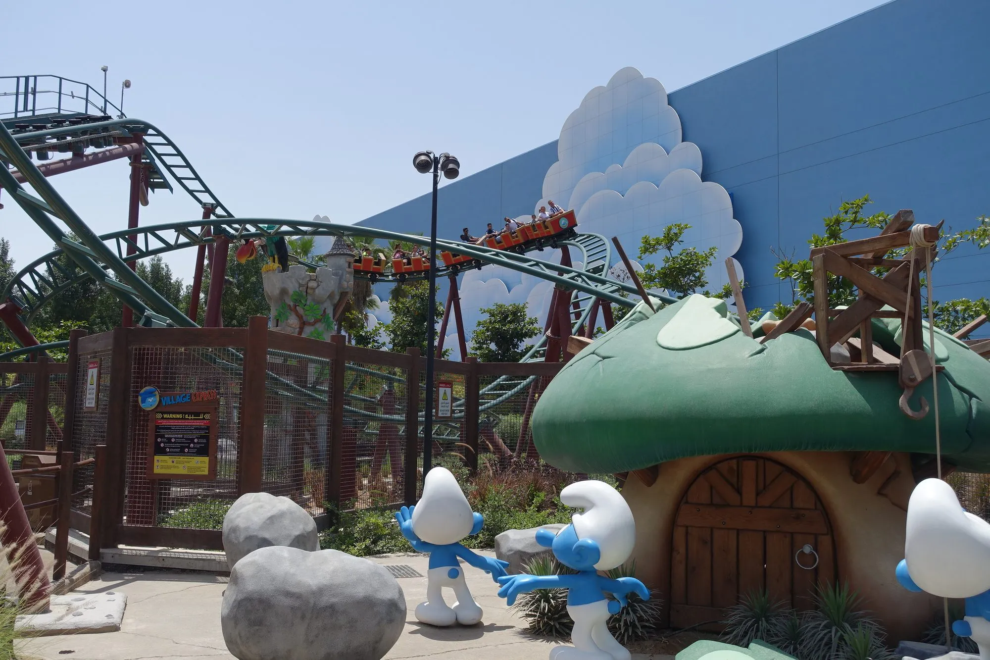 Smurfs Village at Motiongate Dubai with mushroom houses and the Smurfs Express roller coaster under a blue sky